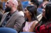 Graduates smiling as they listen to the speeches.